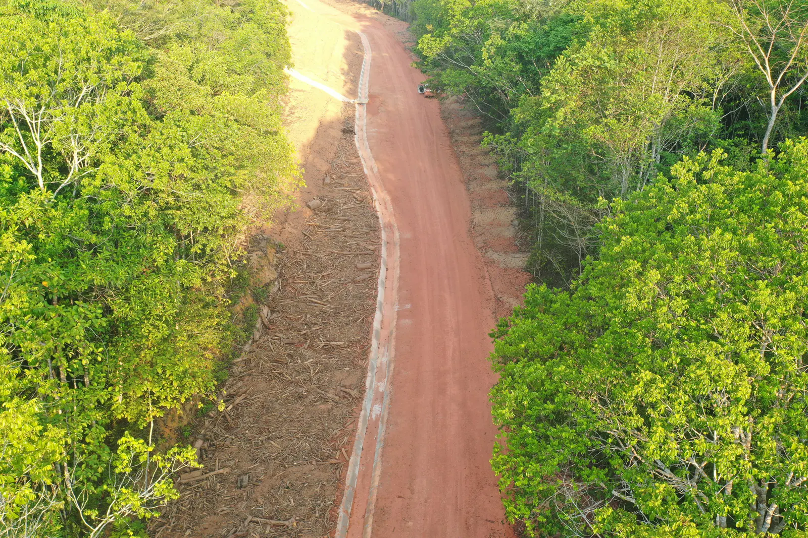 Vista aérea de faixa de talude em conformação entre a floresta, com canaleta de drenagem ao longo